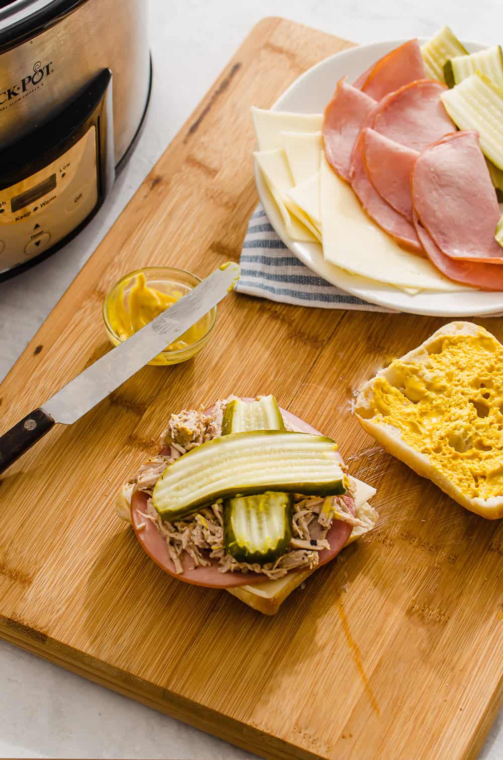 Cuban Panini sandwich ingredients on a cutting board.
