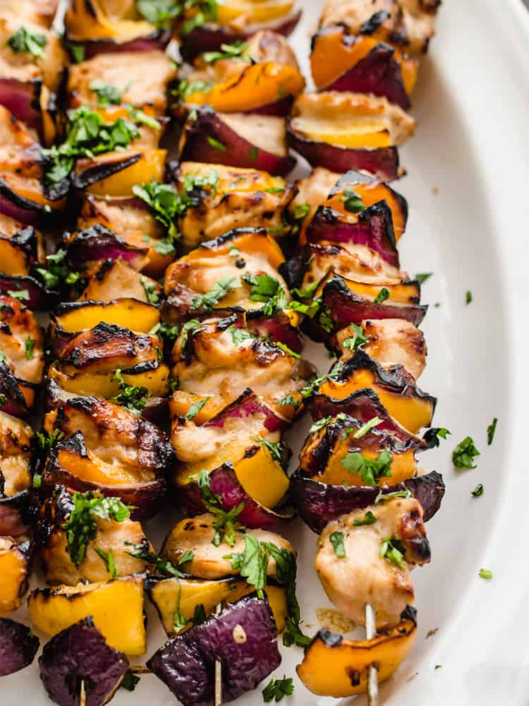 Cooked Honey garlic chicken kabobs on a white platter.