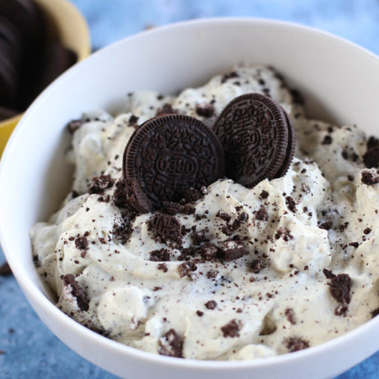 Oreo fluff in a white bowl topped with two whole Oreos.