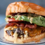 A smash burger with lettuce, tomato, bacon, cheese, and secret sauce.