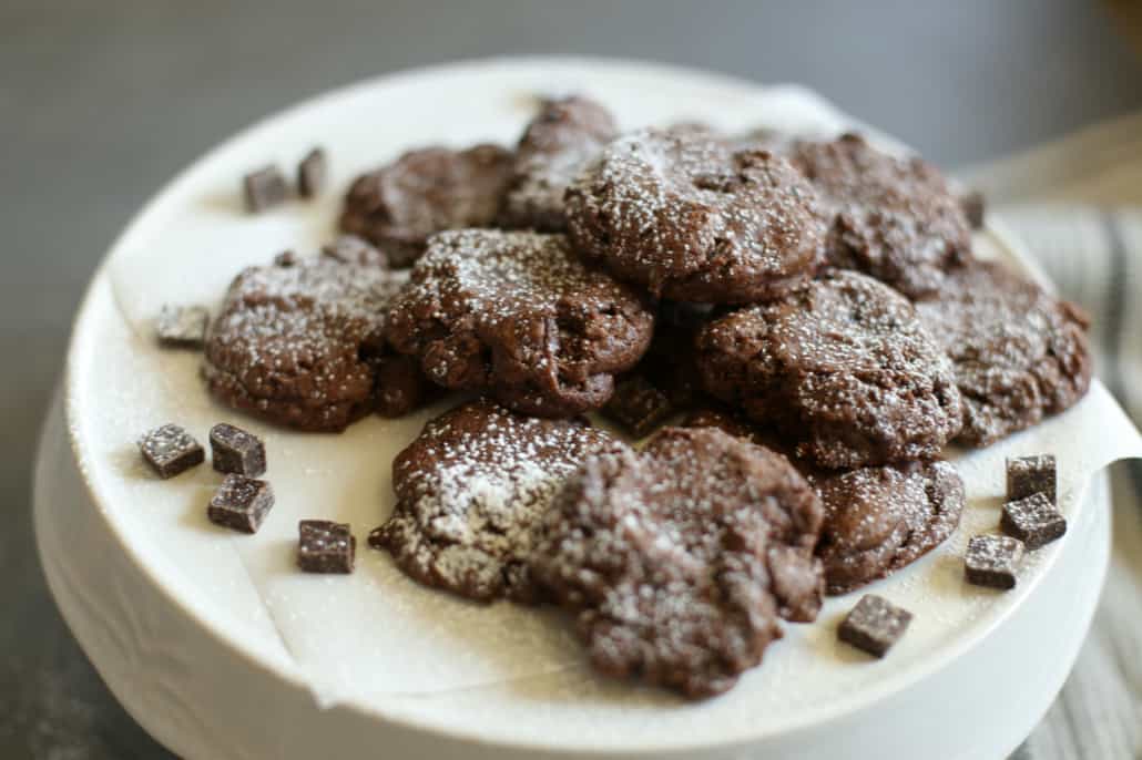 Chocolate Coffee Cookies on a white dish sprinkled with powdered sugar 