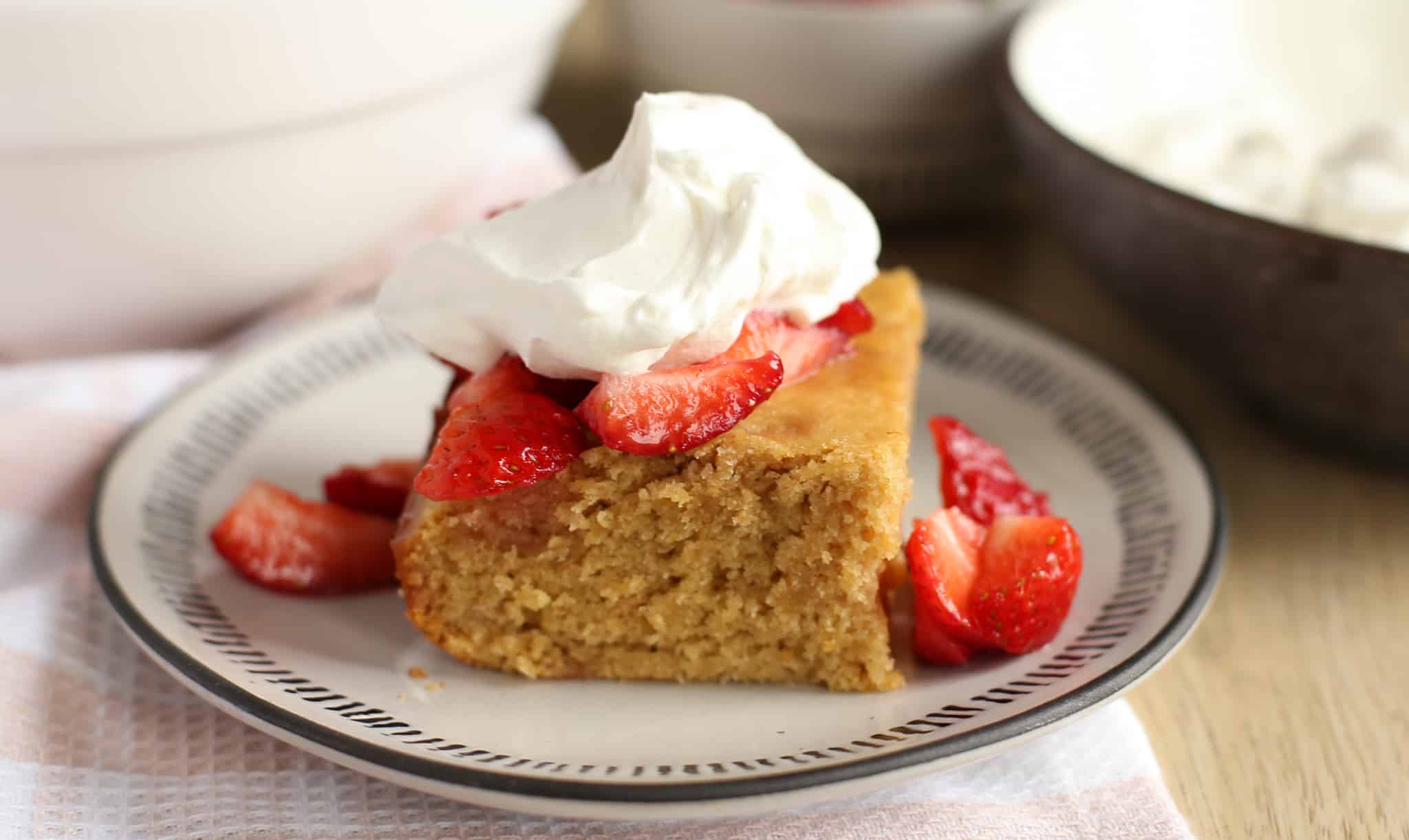 Healthy strawberry shortcake on a plate with homemade whipped cream and strawberries on top.