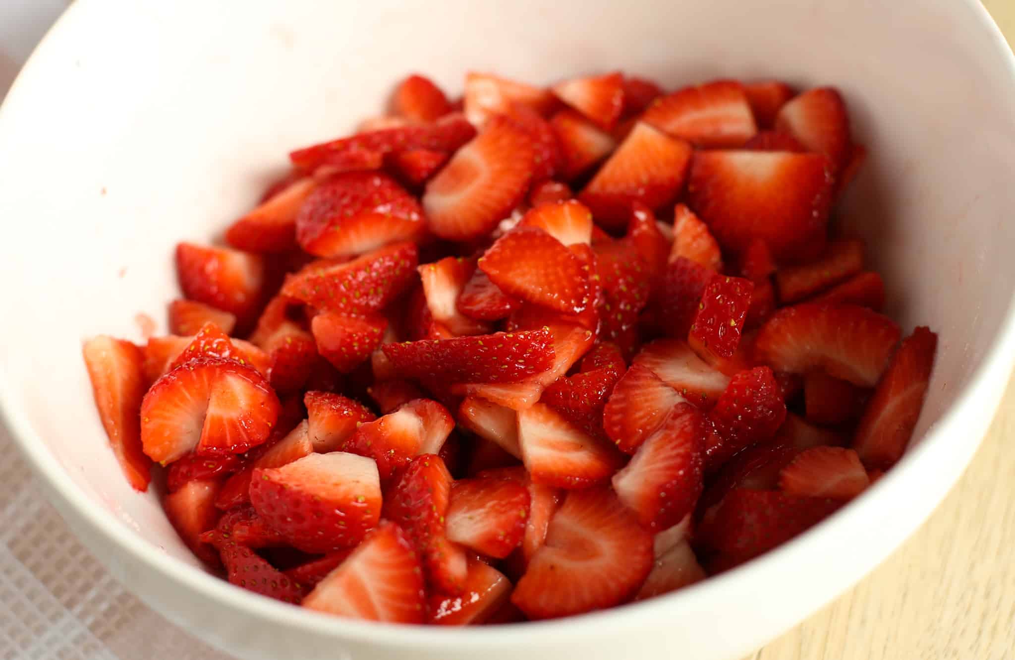 Cut up strawberries in a bowl.