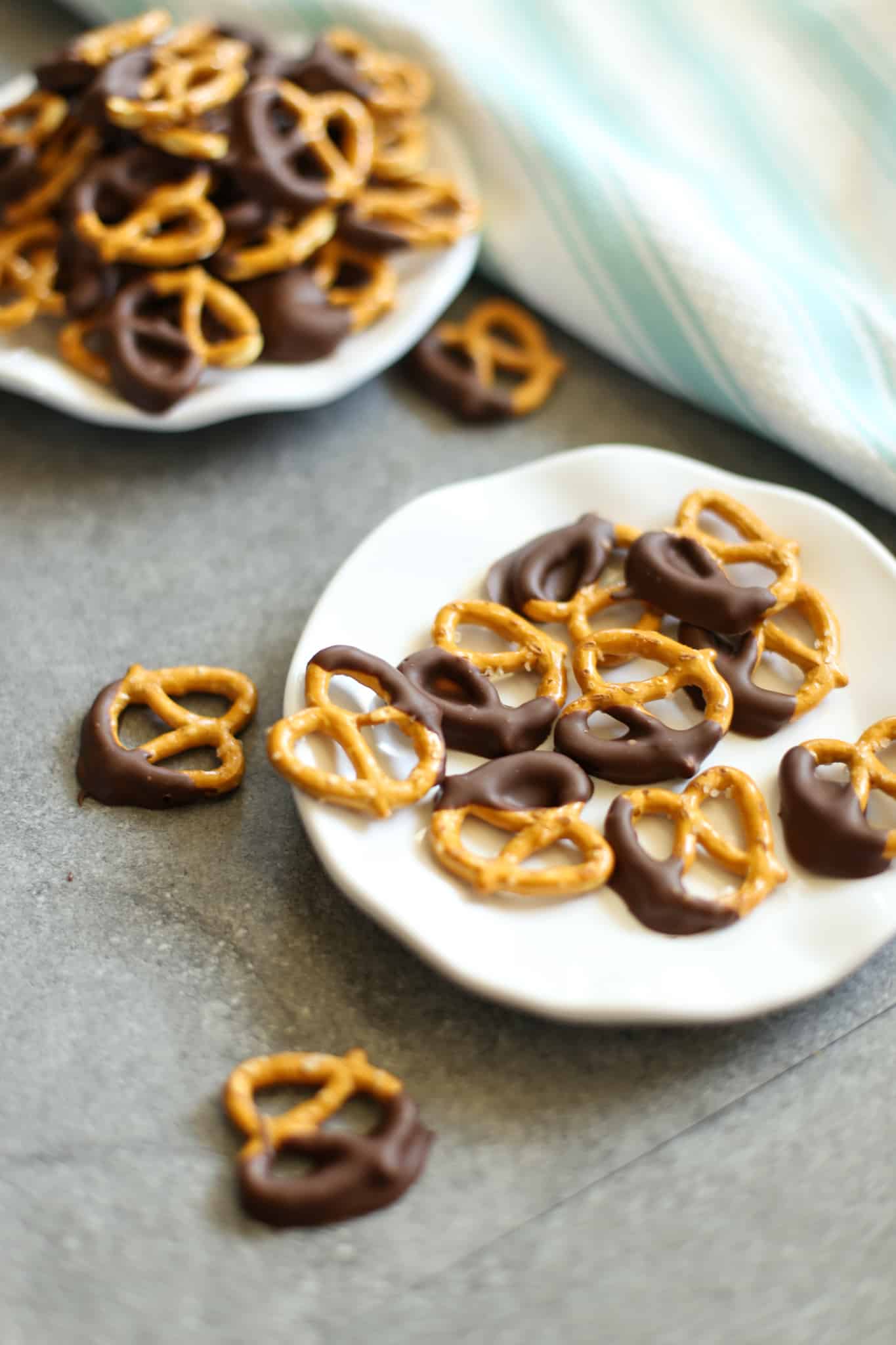 Peanut butter dark chocolate covered pretzels on a white plate.