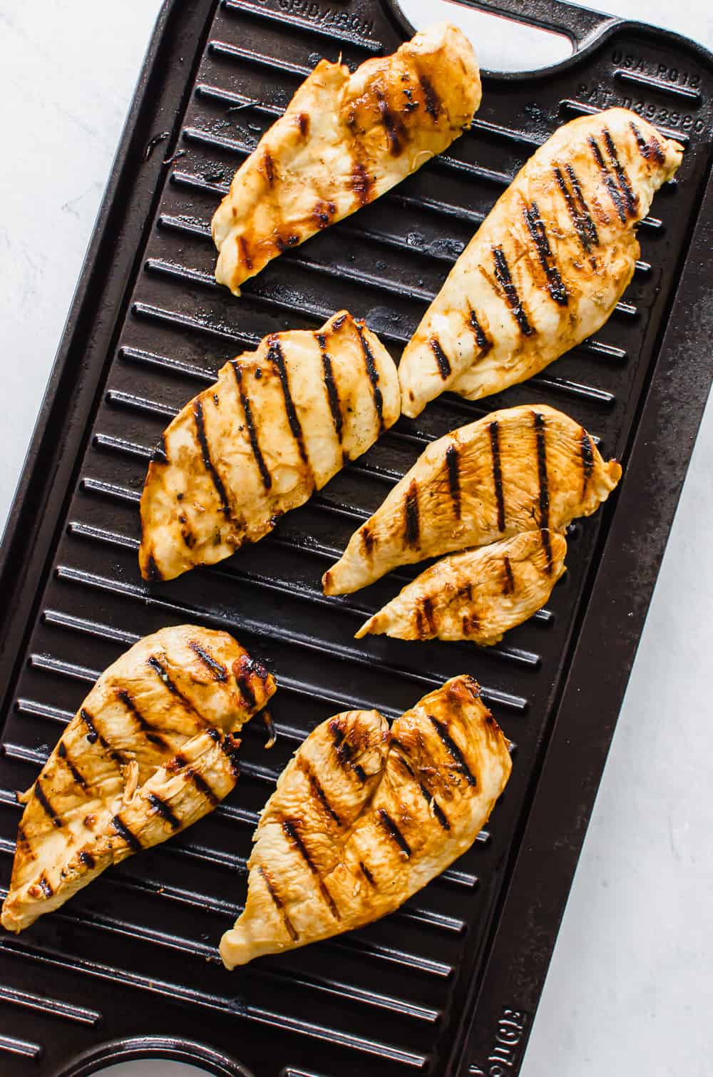 Honey dijon chicken cutlets being grilled.