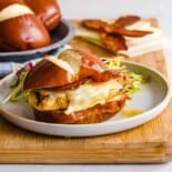 Honey dijon chicken sandwiches on a cutting board.