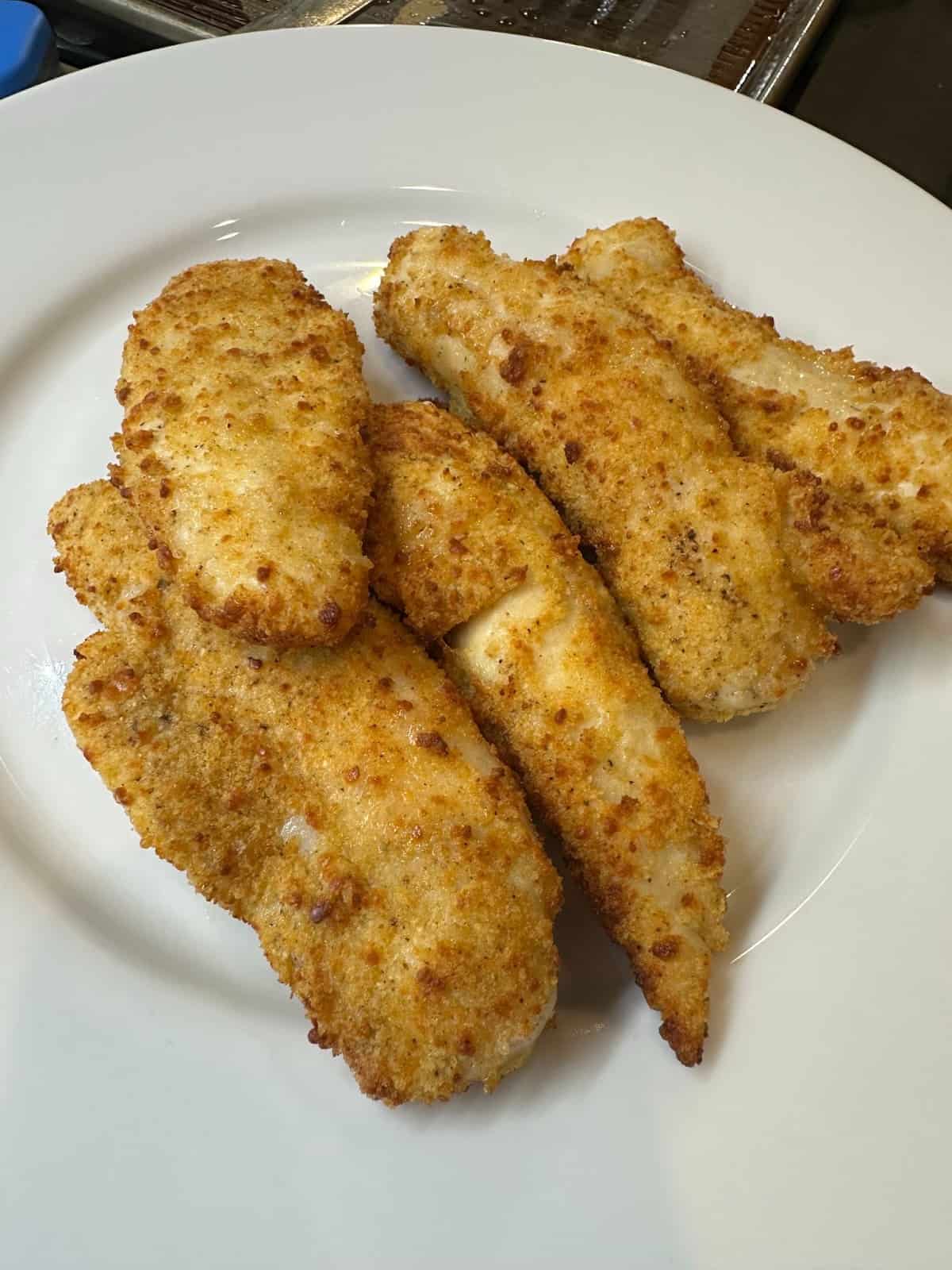 Air fried chicken tenders on a plate.