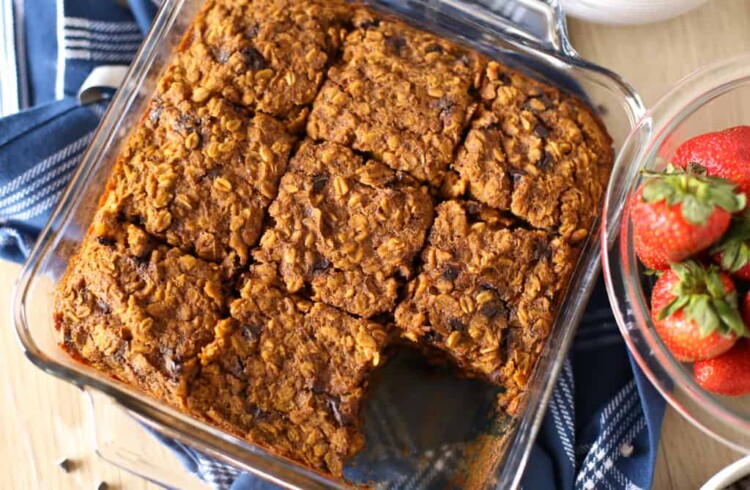 Pumpkin baked oatmeal in a square glass dish cut in nine squares with one missing.