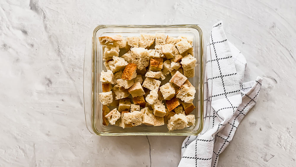 cubed bread pieces in a glass casserole dish