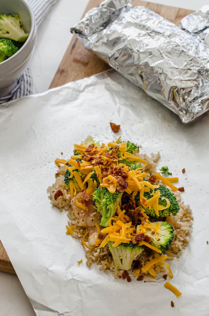 rice, chicken, broccoli, cheese, and bacon on a piece of foil