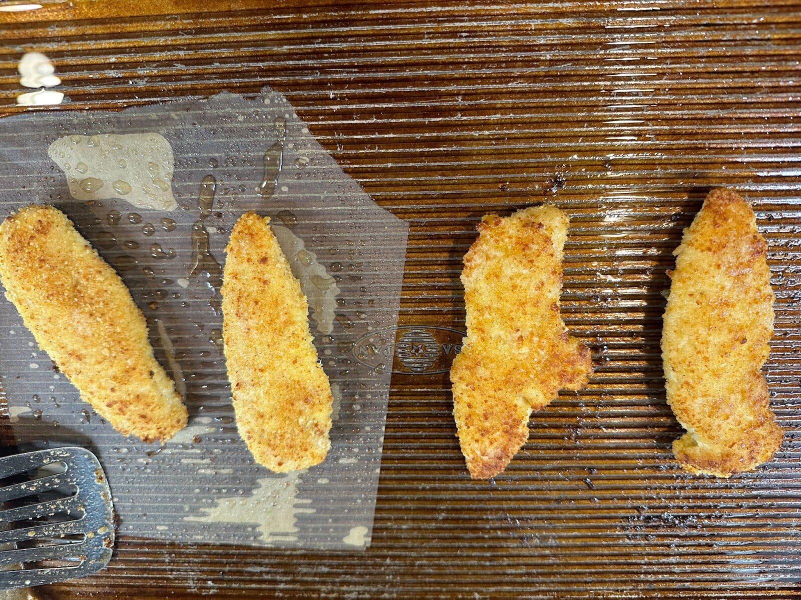 Baked chicken tenders test results on parchment paper vs. on the sheet pan.