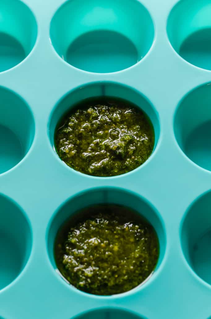 small portions of pesto in a container for freezing 
