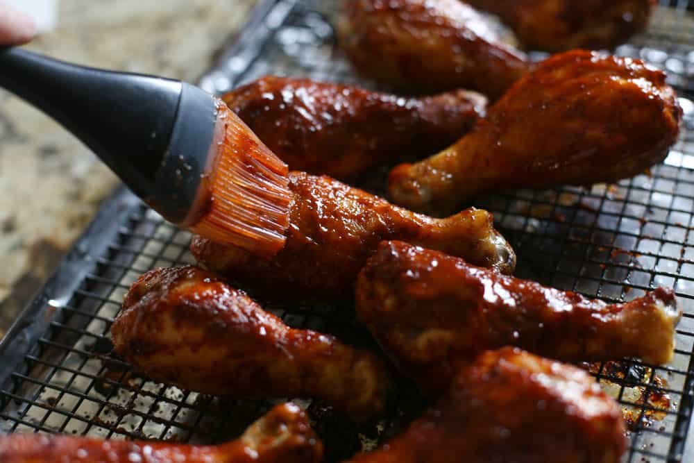 Basting drumsticks with BBQ sauce 