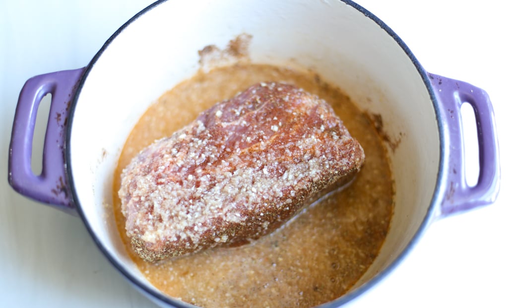 Pork shoulder in a Dutch Oven with seasoning and marinade