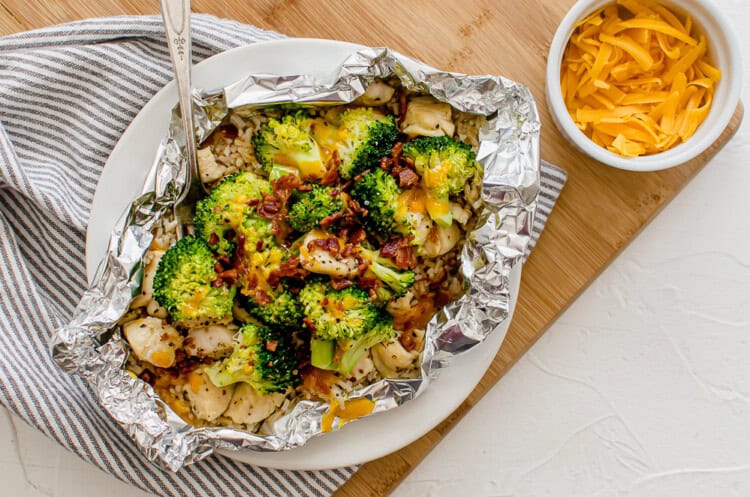 Chicken, broccoli, rice, and cheese foil packet opened on a plate ready to eat.