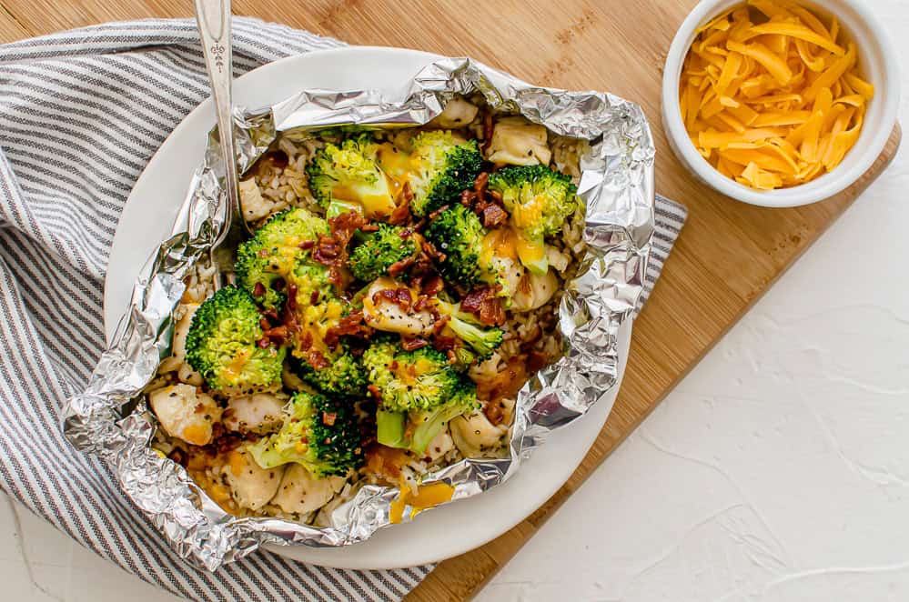 Chicken, broccoli, rice, and cheese foil packet opened on a plate ready to eat.