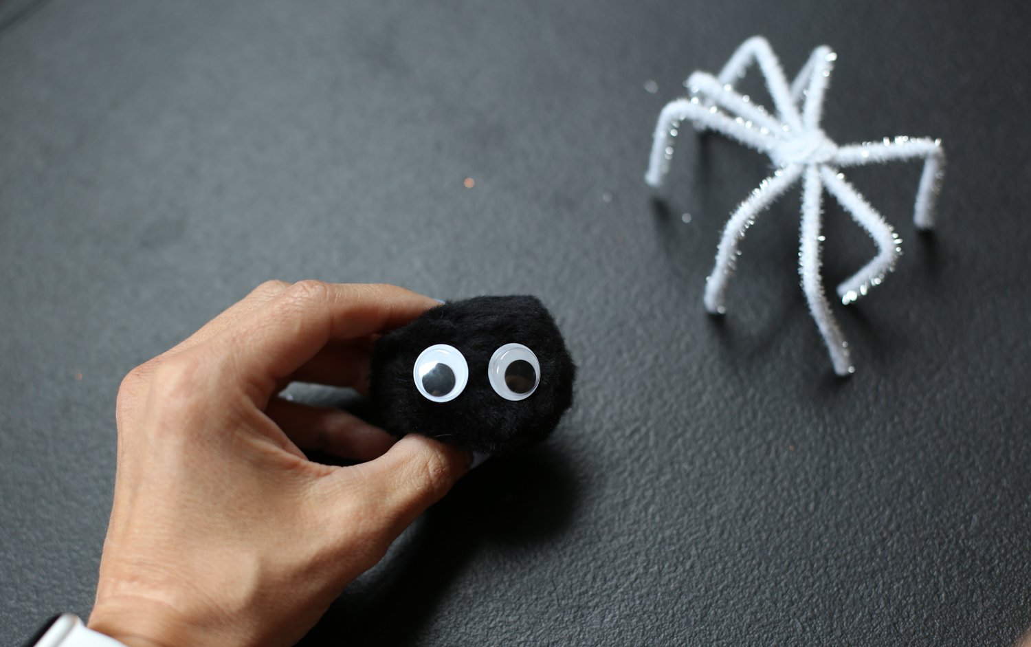 googly eyes attached to a pom pom to make a spider craft