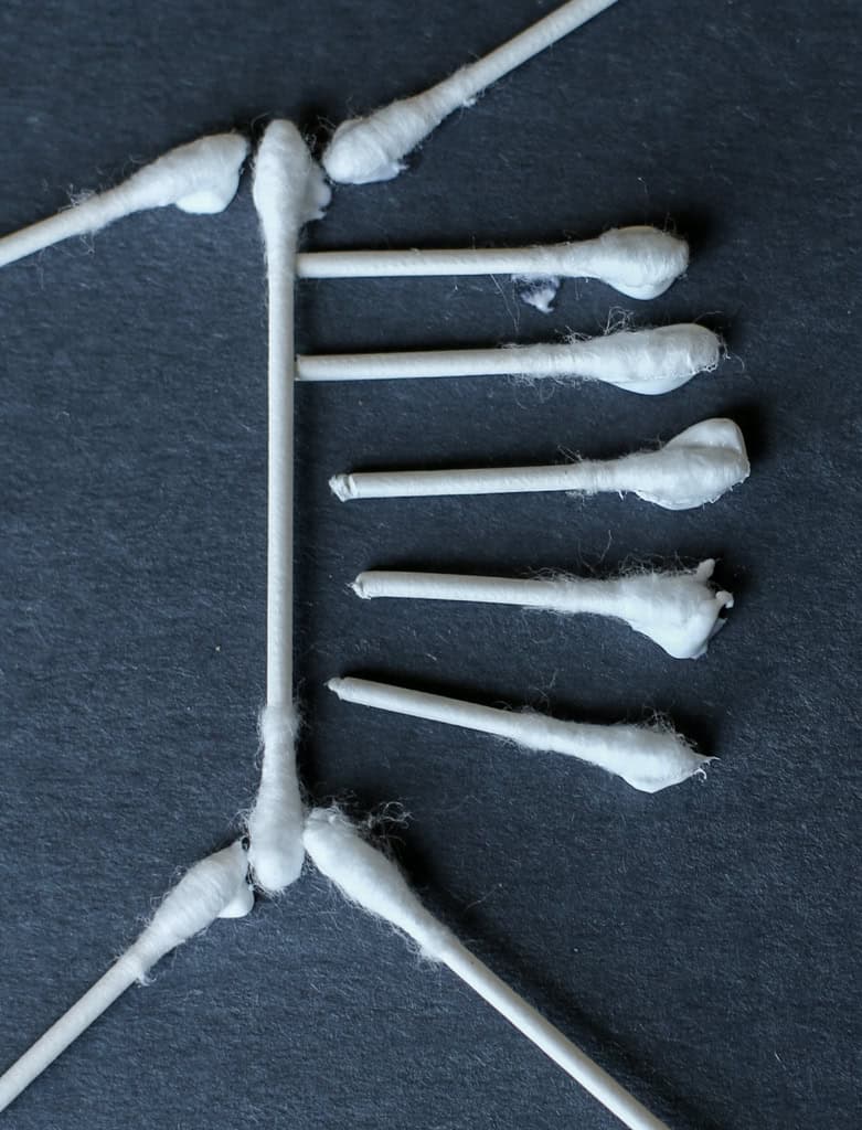 Close up of glue on Q-tips while making a Q-tip skeleton.