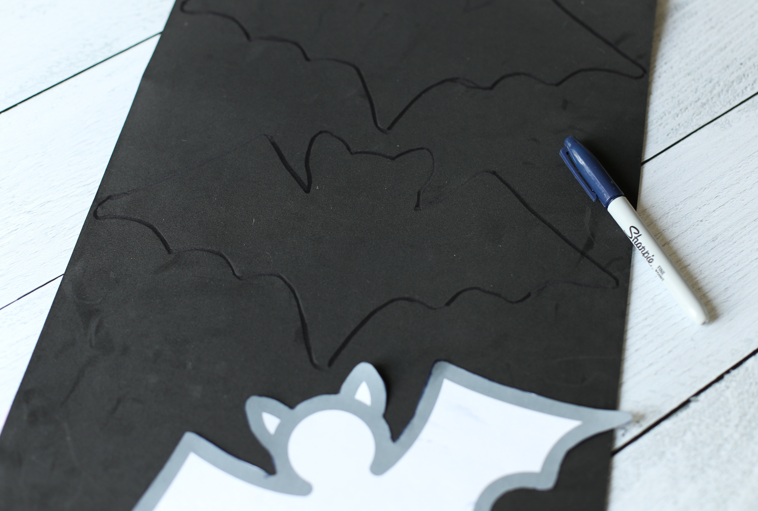 Tracing a bat template on black foam paper.
