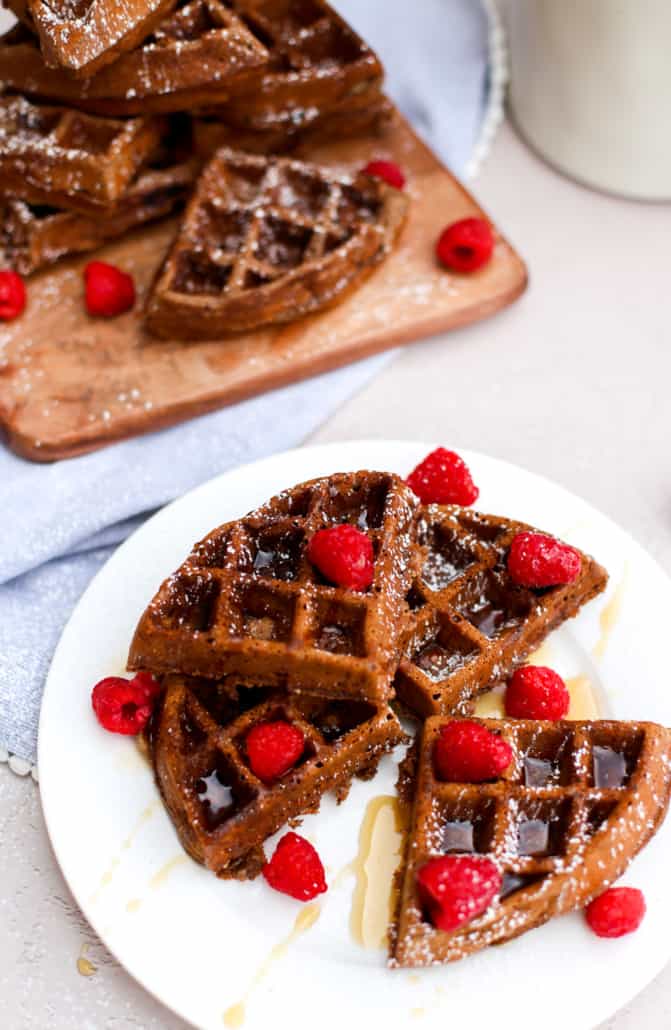 Chocolate waffles with raspberries on a white plate