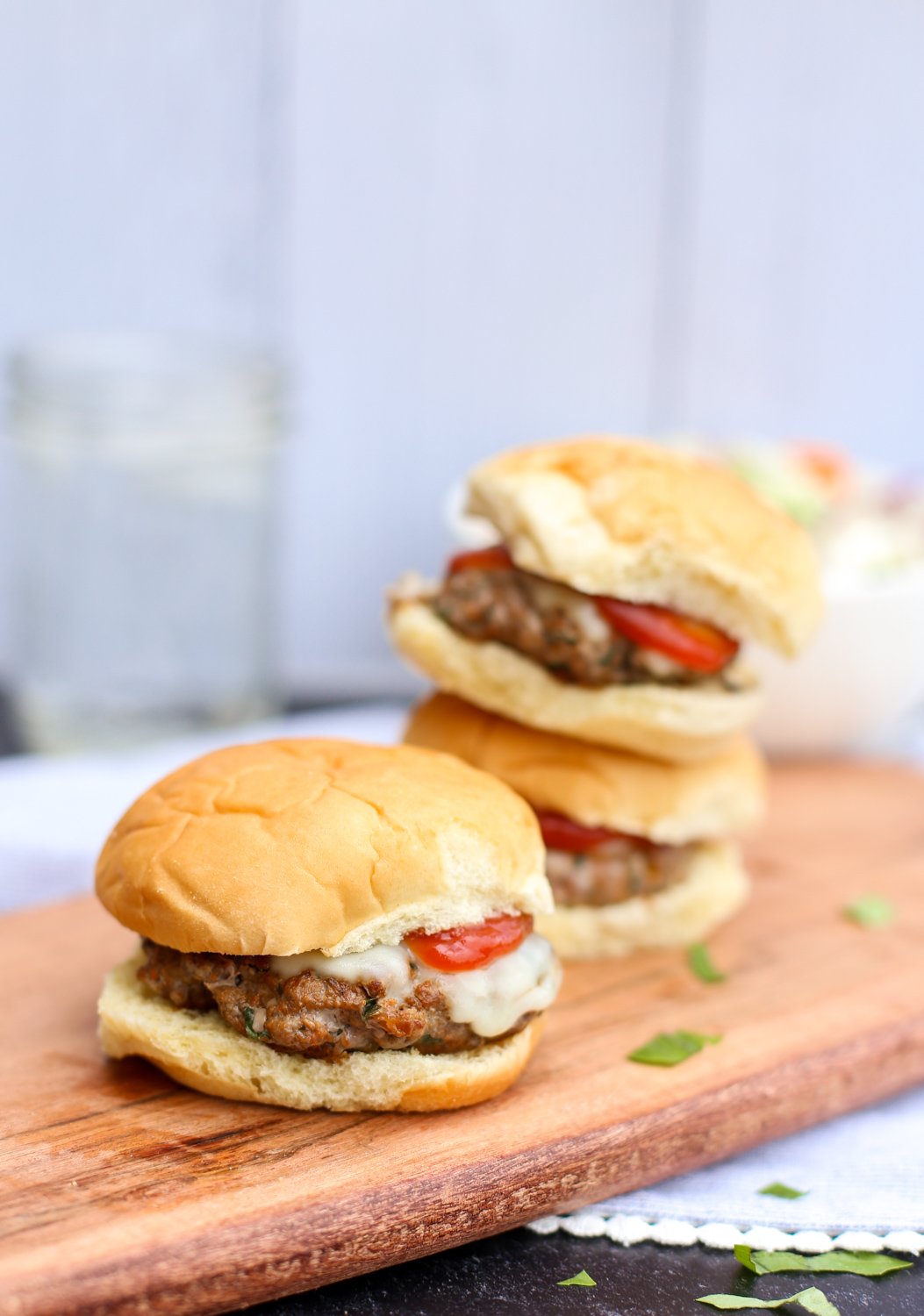 Italian sliders stacked on a cutting board.