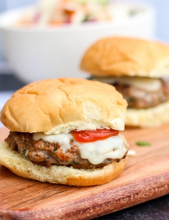 Italian sliders lined up on a cutting board.