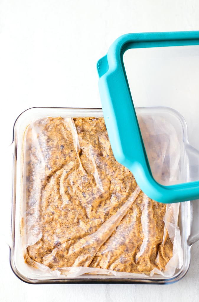 Baked Oatmeal in a glass casserole dish covered by plastic wrap with a glass lid being placed on top.
