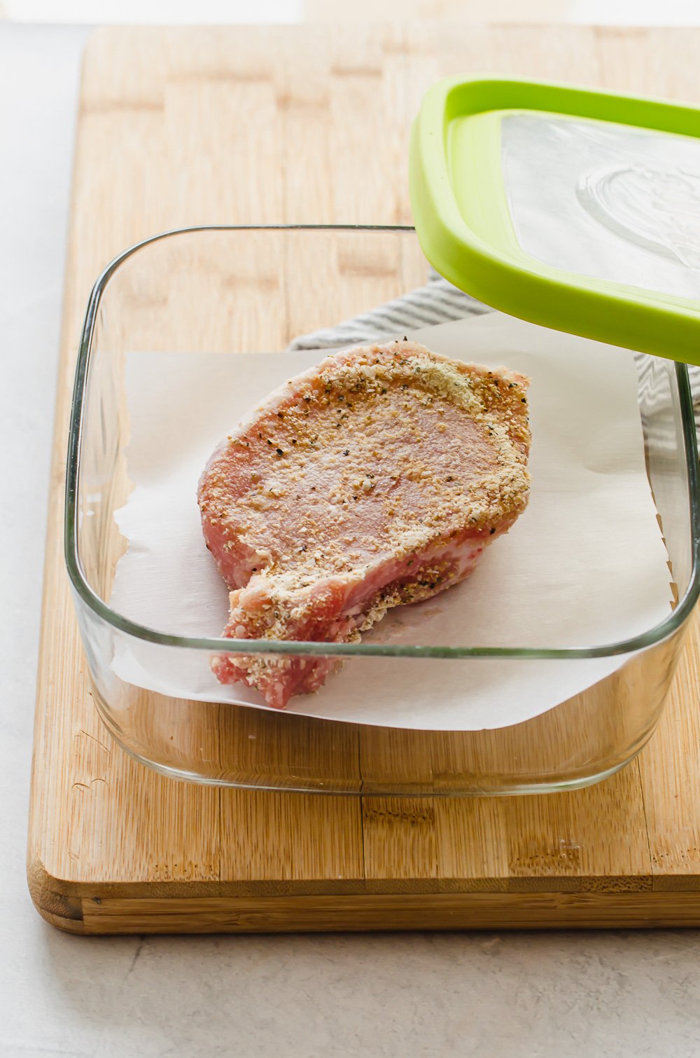 Seasoned pork chops in a freezer container.