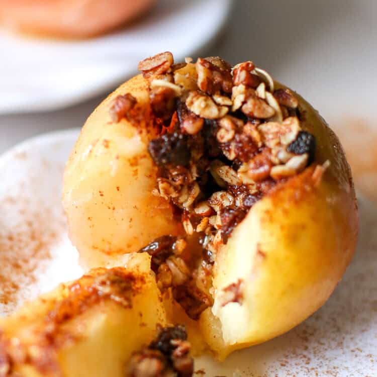 A baked apple split open with the filling spilling out.