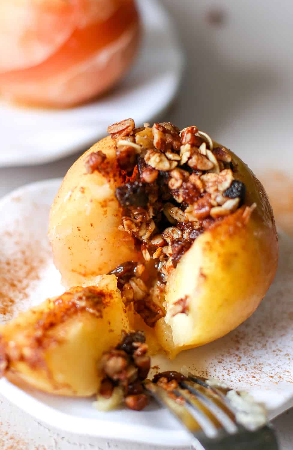 A baked apple split open with the filling spilling out.