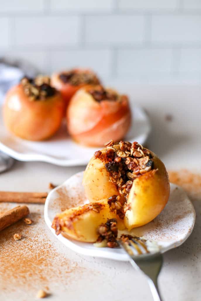 A baked apple sliced open with filling spilling out