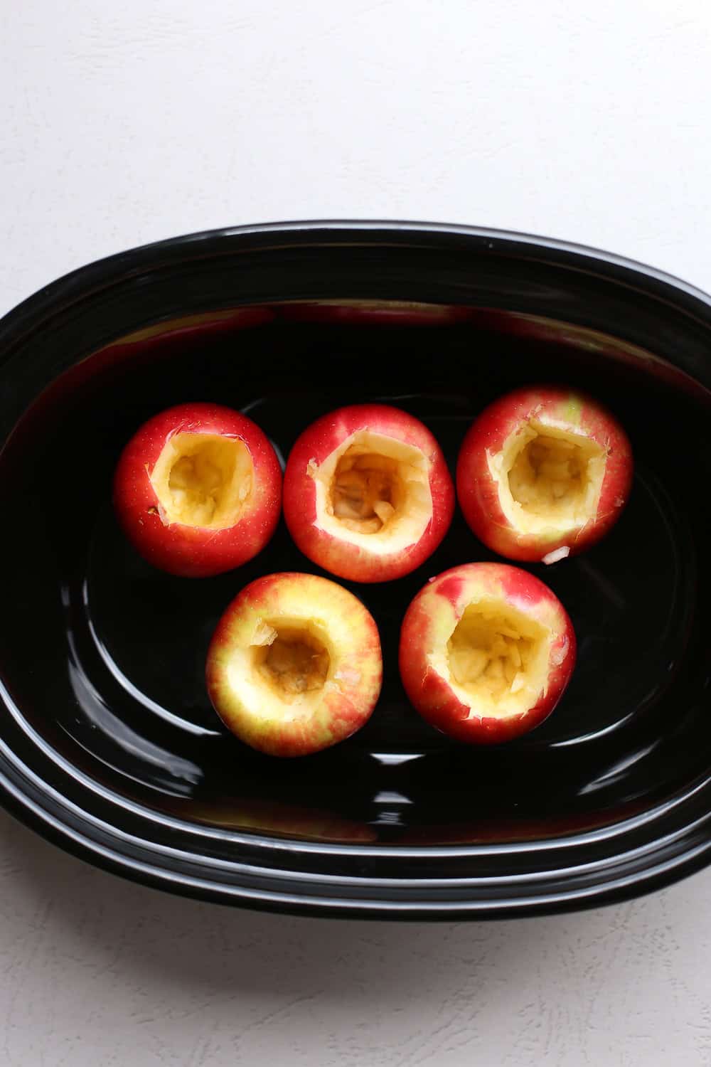 Cored apples in a crockpot.