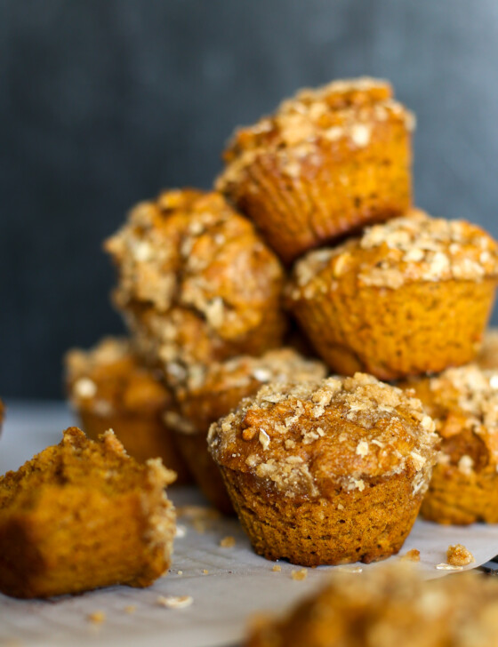 Pumpkin spice muffins stacked on a colling rack.
