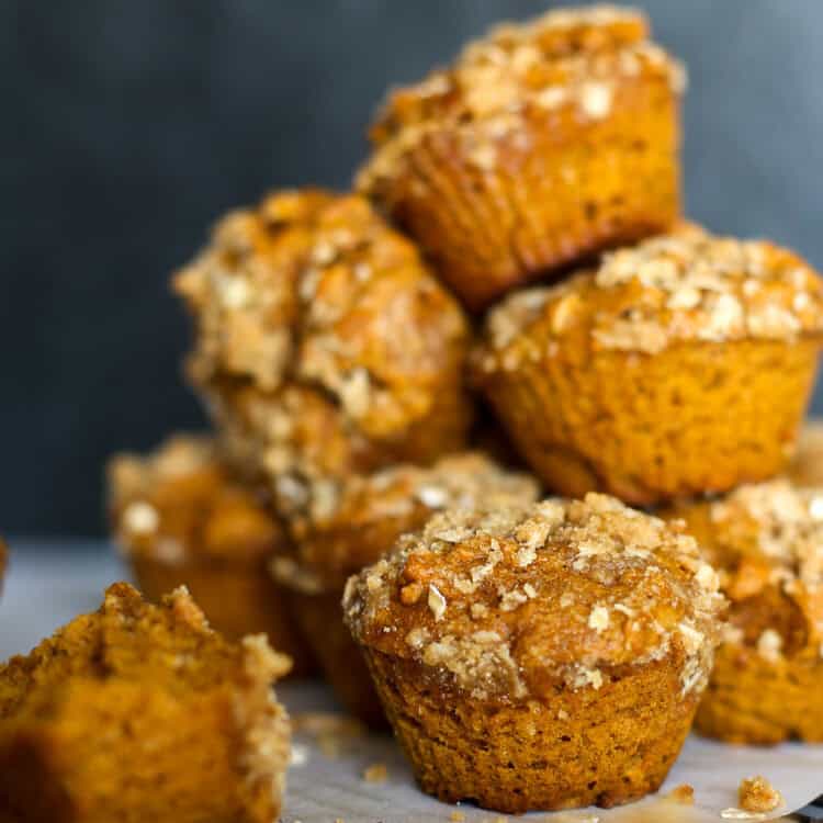 Pumpkin spice muffins stacked on a colling rack.