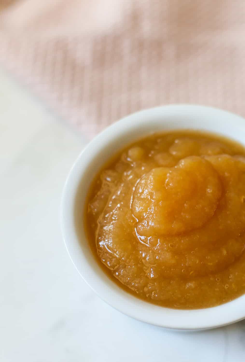 Crock pot apple sauce in a white bowl.