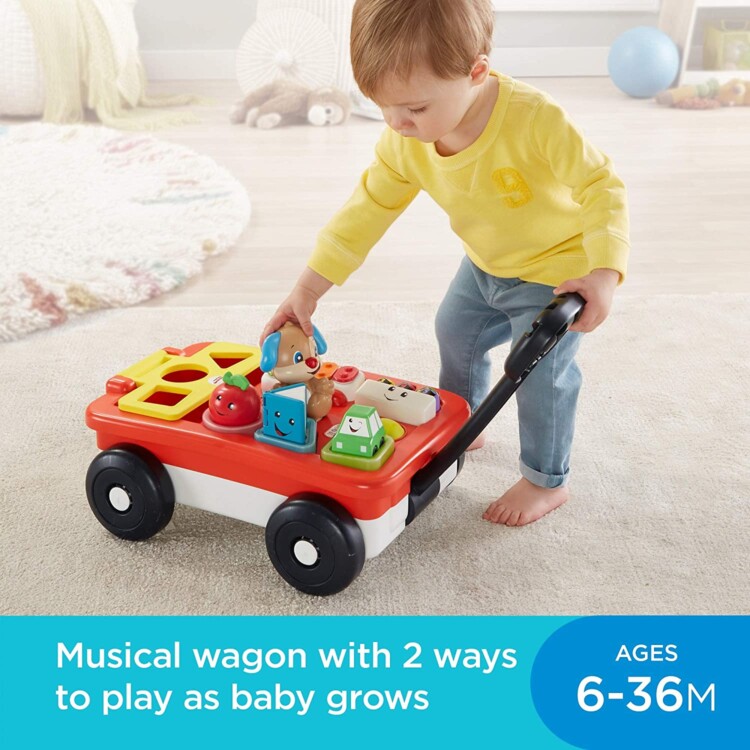Child playing with a hard-plastic wagon that has different ways to push or move things to have it make music.