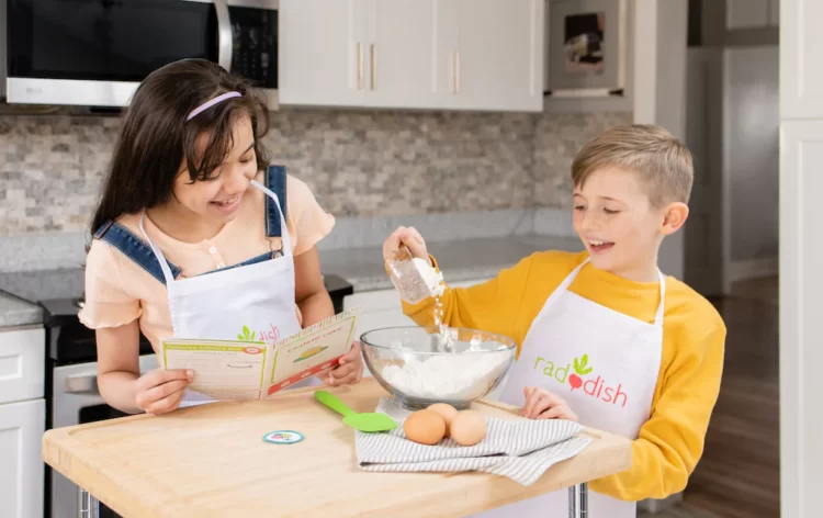 Kids cooking with Raddish Kids aprons on.