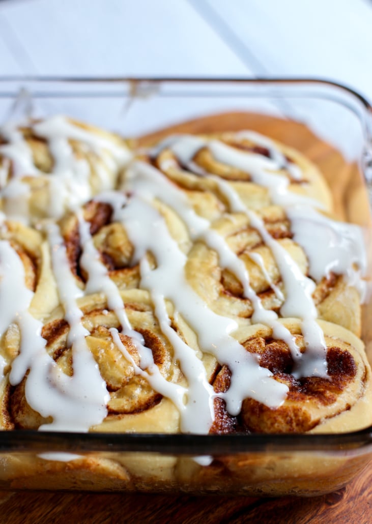 Cinnamon Rolls with glaze in a glass baking dish.
