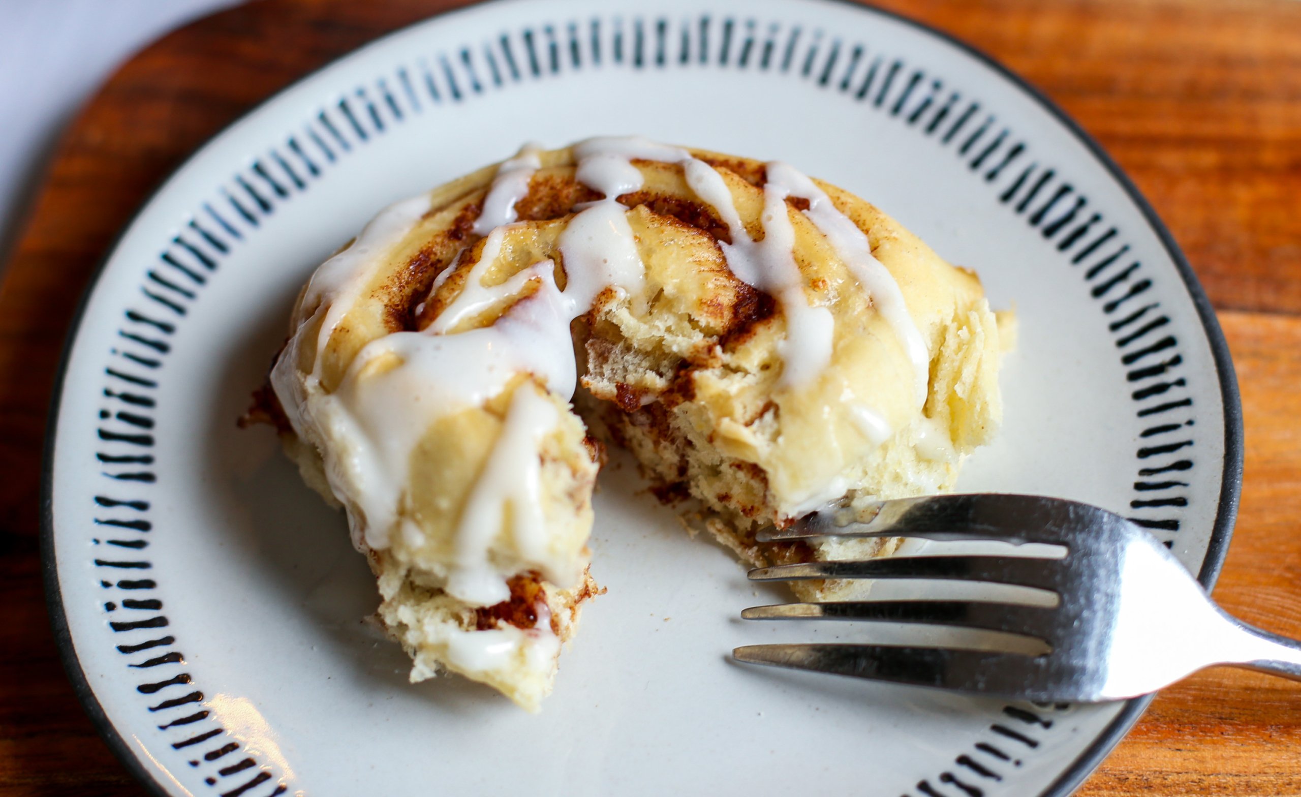 Baked cinnamon roll with a bite cut out. 