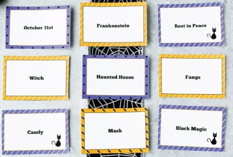 Halloween Charades words printed on cards and laid out on a table.