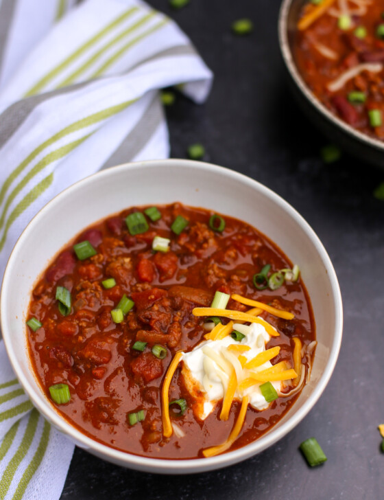 Stove top chili with sour cream and shredded cheddar on top