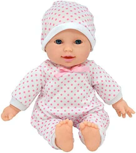 Baby doll in a white onesie with pink polka dots and matching cap.