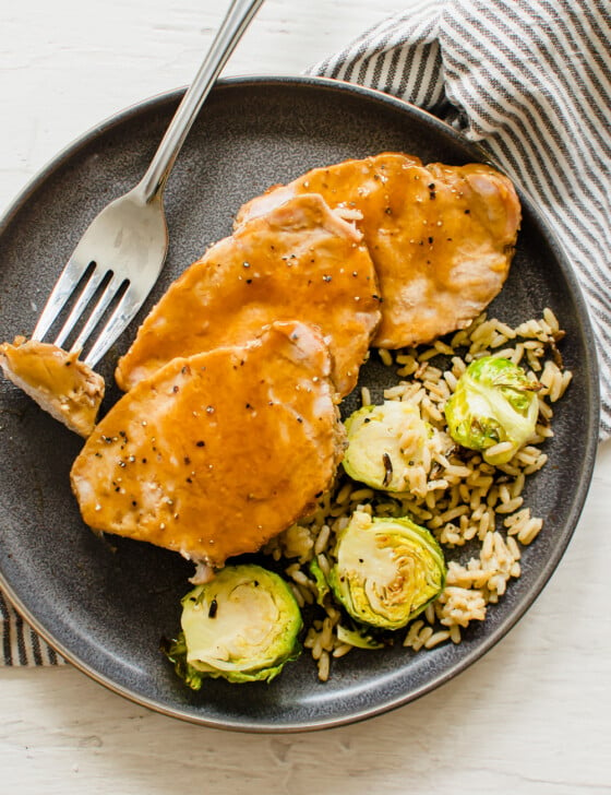 maple glazed pork on a plate with brussels and rice