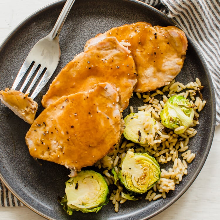 maple glazed pork on a plate with brussels and rice