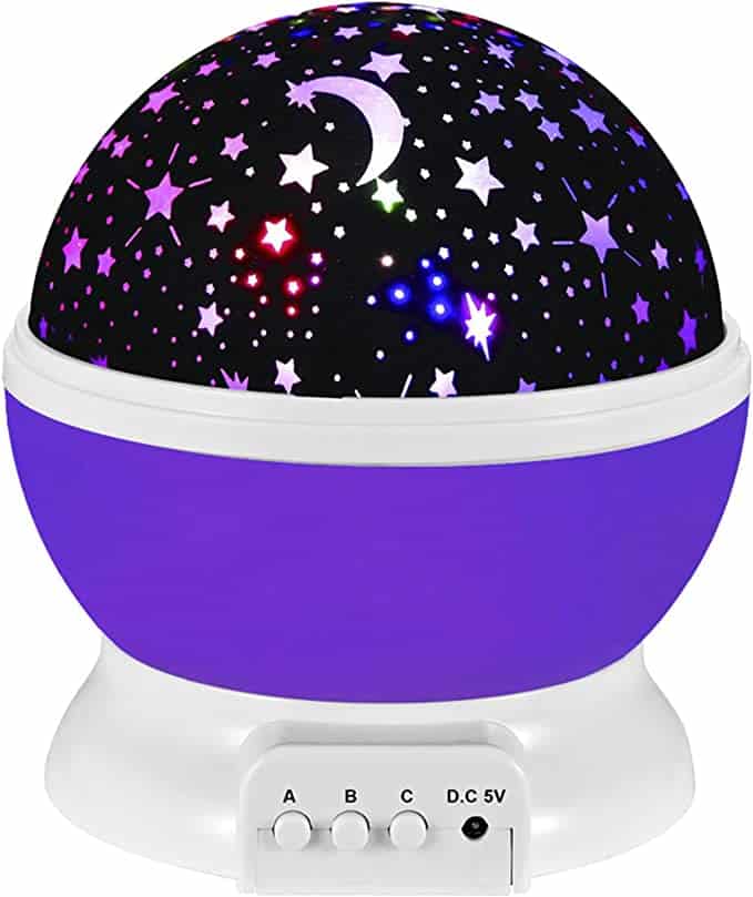 A starry night light with a purple base and the top is black with light coming out of moon and star shapes.