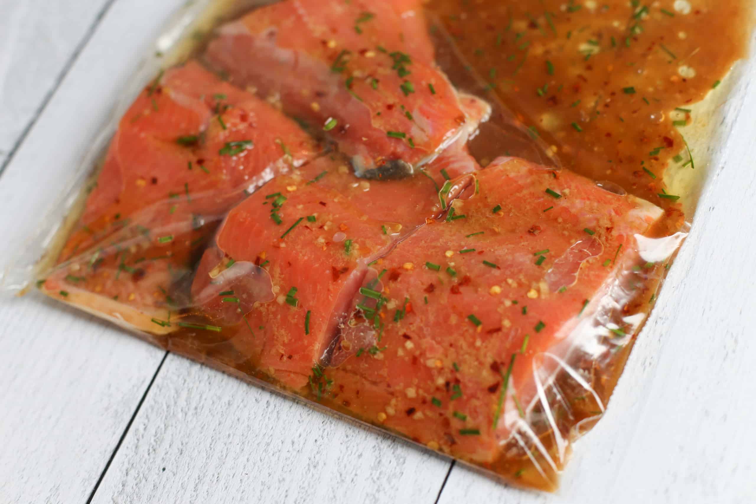 Salmon fillets marinating in a plastic bag.