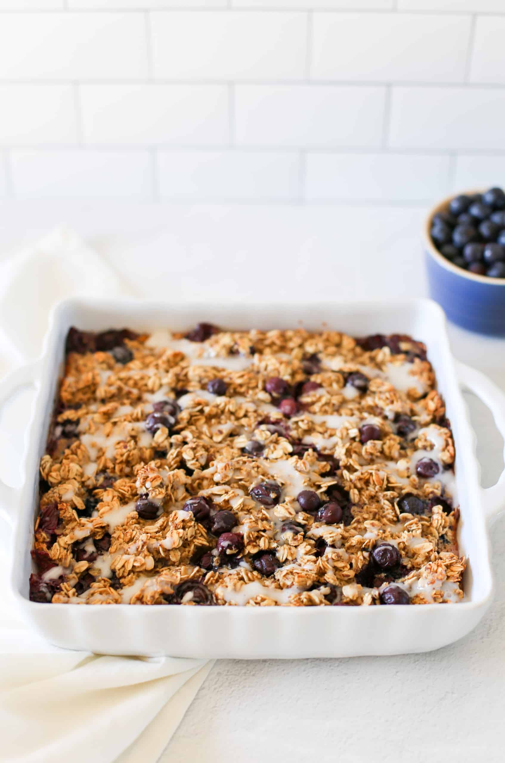 Blueberry baked oatmeal in a white baking dish ready to be served.