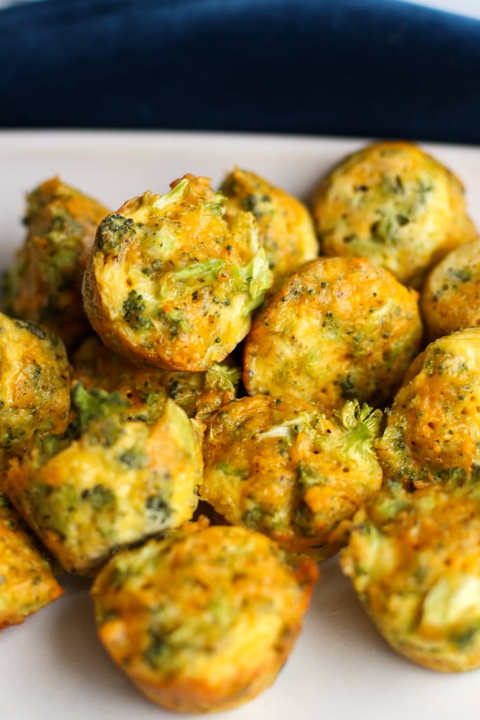 A pile of broccoli bites on a white plate