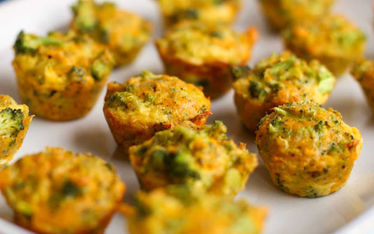 close up of broccoli cheddar bites lined up on a white serving platter