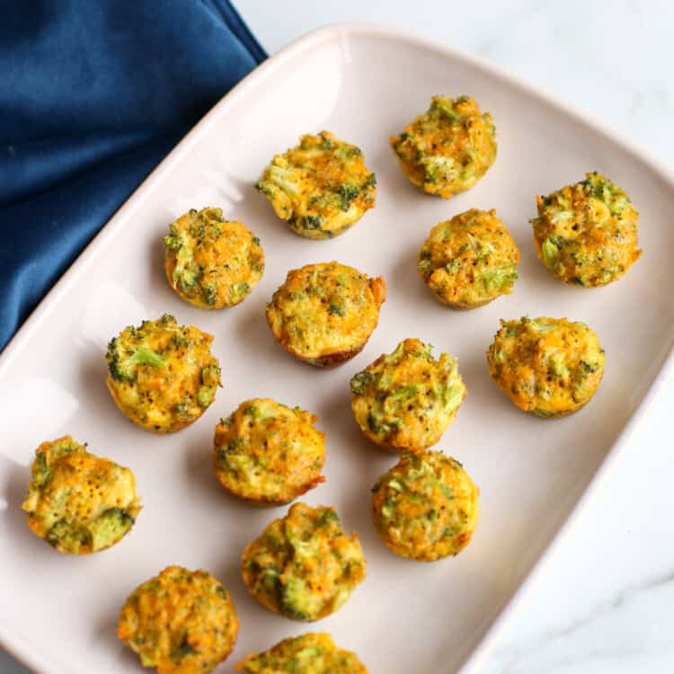 overhead shot of broccoli cheddar bites lined up on a white serving platter